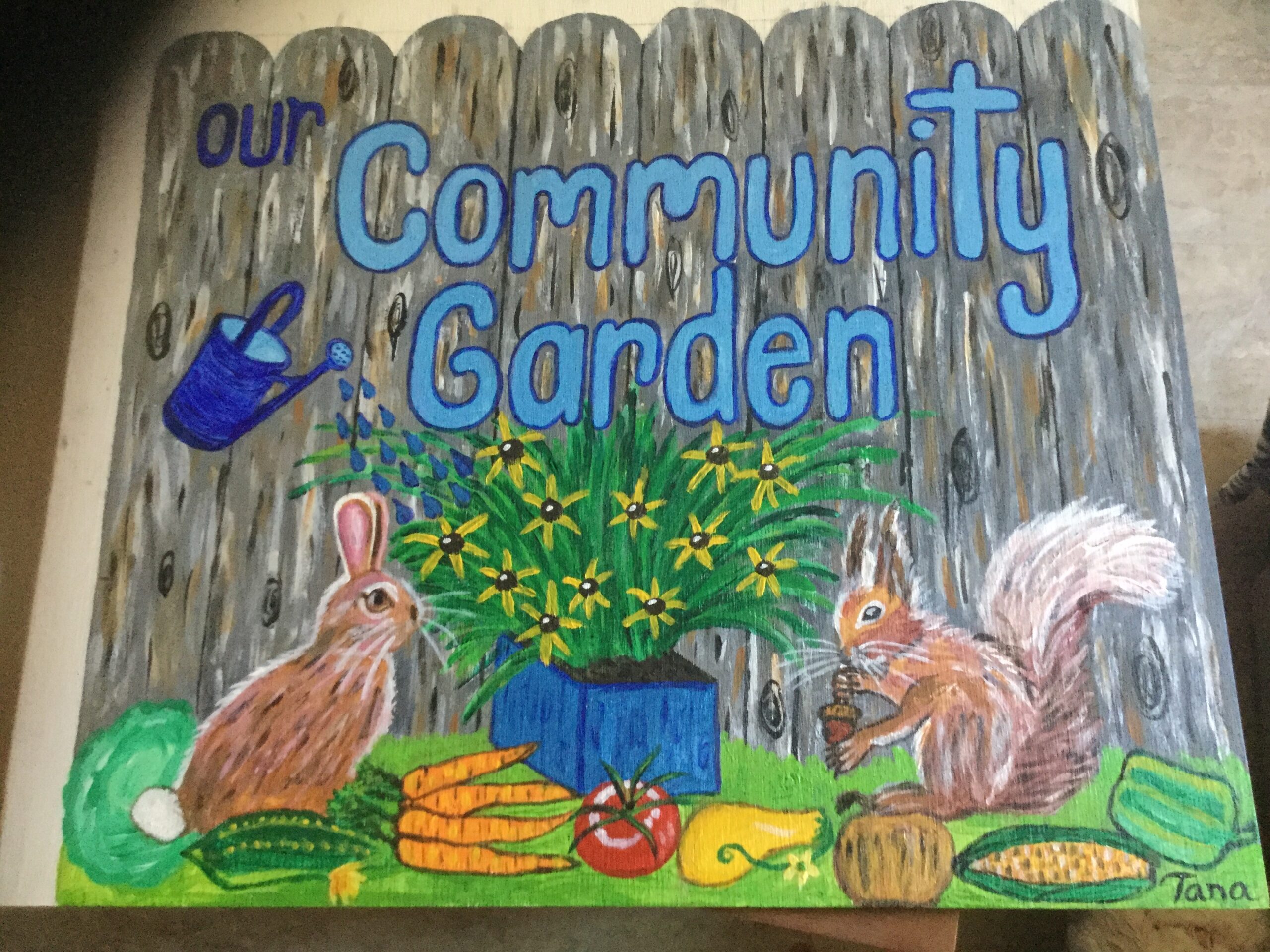 Community Garden painted sign with squirrel and bunny