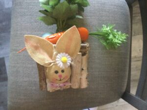 Easter table centerpiece with carrot, bunny face, eggs and wood bark on a glass square bowl