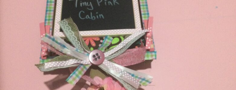 chalkboard sign on wood stand with ribbon and flowers