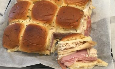 Hawaiian rolls with chicken, ham, swiss and sauce baked in oven